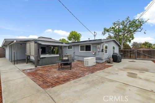 1230 Kilson Dr, Santa Ana, CA 92707 - rear view of property with a hot tub, a patio area, and a gate