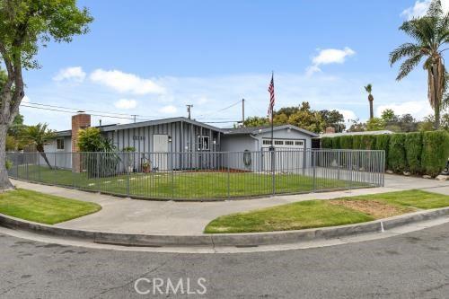 1230 Kilson Dr, Santa Ana, CA 92707 - ranch-style house with a fenced front yard, a garage, concrete driveway, and board and batten siding