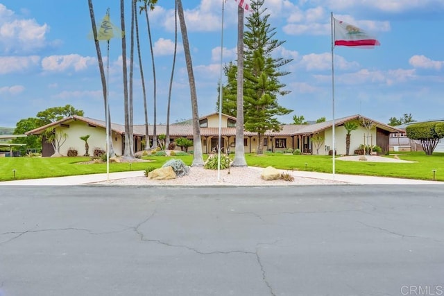 mid-century modern home featuring a front yard and stucco siding