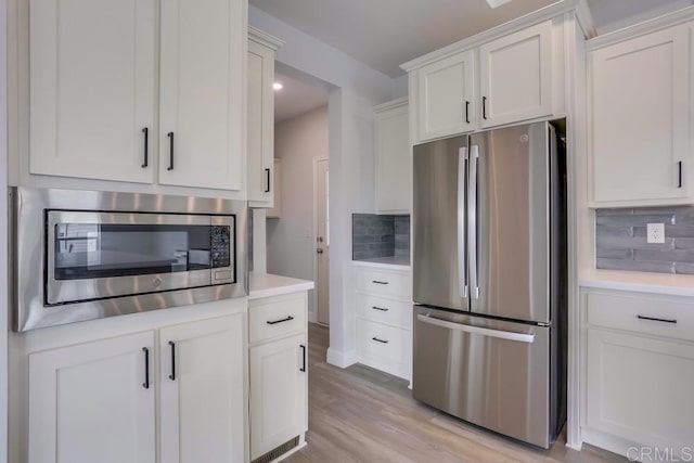 kitchen featuring light countertops, backsplash, and appliances with stainless steel finishes