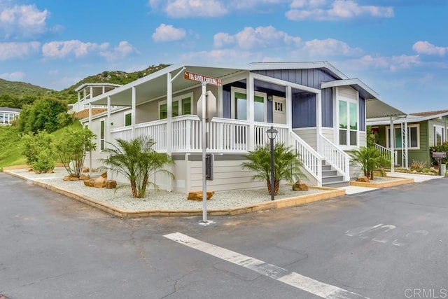 manufactured / mobile home with board and batten siding and a porch