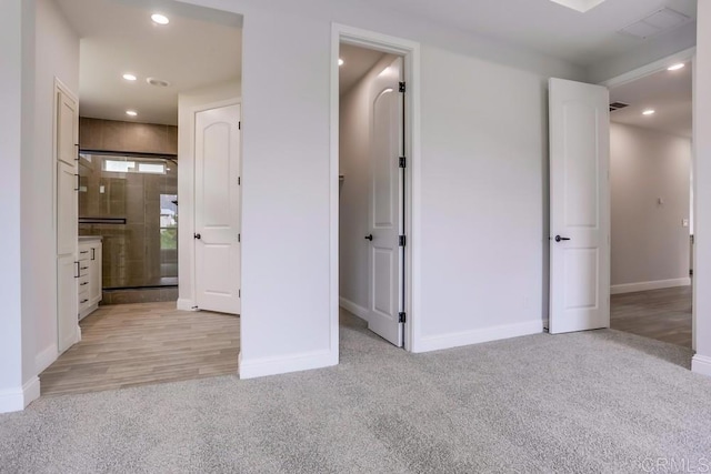 unfurnished bedroom featuring light carpet, baseboards, and recessed lighting
