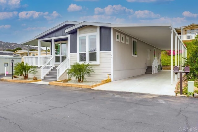 manufactured / mobile home featuring a carport and aphalt driveway