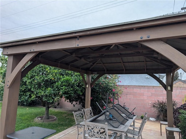 view of patio with outdoor dining area, a gazebo, and fence