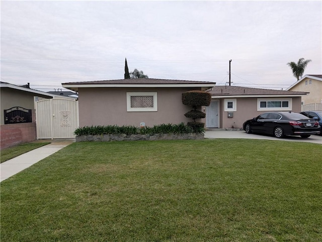 ranch-style home featuring stucco siding and a front lawn