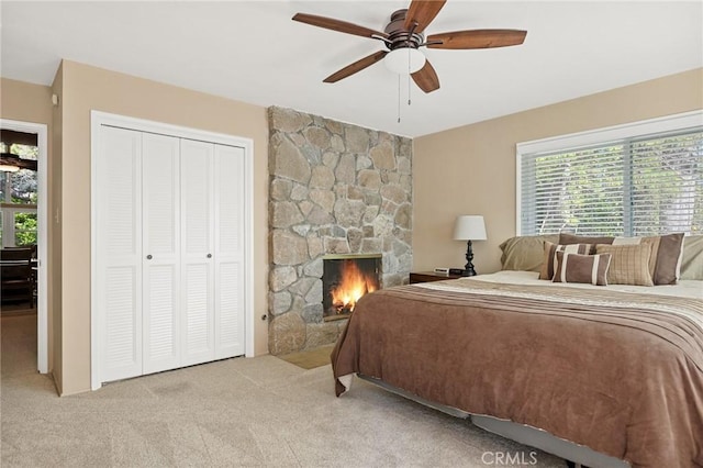 693 Old Meadow Pl, Lake Arrowhead, CA 92352 - bedroom featuring light carpet, a ceiling fan, a stone fireplace, and a closet