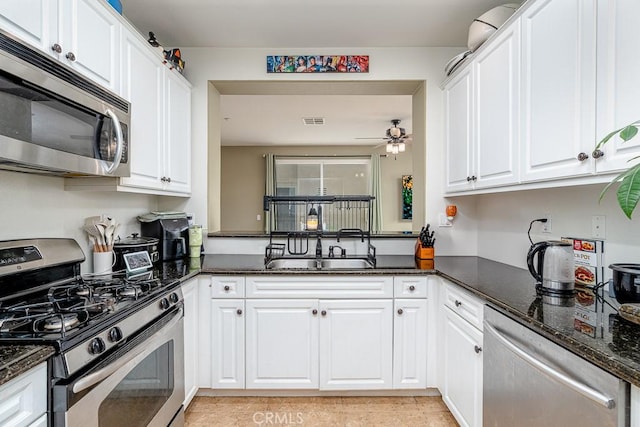 35806 Springvale Ln Unit 2, Murrieta, CA 92562 - kitchen with appliances with stainless steel finishes, ceiling fan, white cabinets, a sink, and dark stone counters