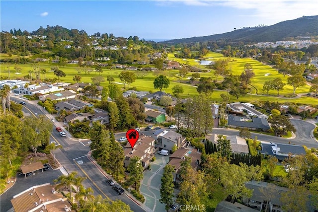 drone / aerial view with a water and mountain view, a residential view, and view of golf course