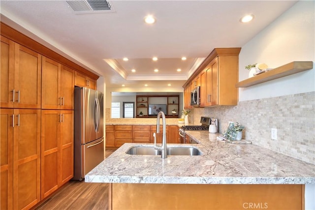 kitchen featuring open shelves, a sink, appliances with stainless steel finishes, visible vents, and a peninsula