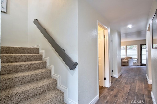 stairs featuring wood finished floors and baseboards