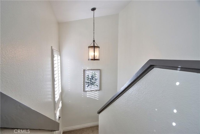 staircase with carpet flooring, lofted ceiling, and baseboards
