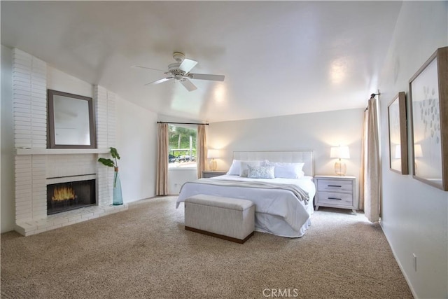 carpeted bedroom featuring ceiling fan, a fireplace, and vaulted ceiling