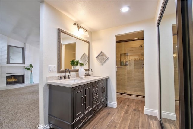 bathroom featuring a shower stall, double vanity, and a sink