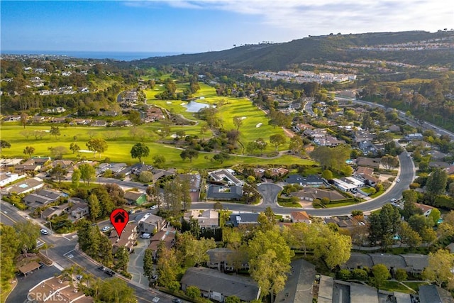 drone / aerial view featuring a water and mountain view, golf course view, and a residential view