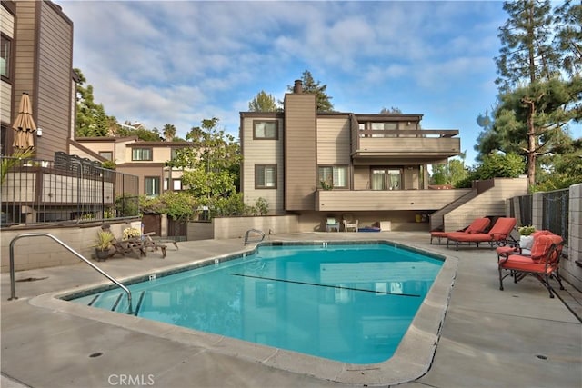 community pool featuring fence and a patio