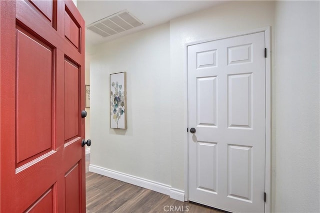 hallway with visible vents, dark wood finished floors, and baseboards