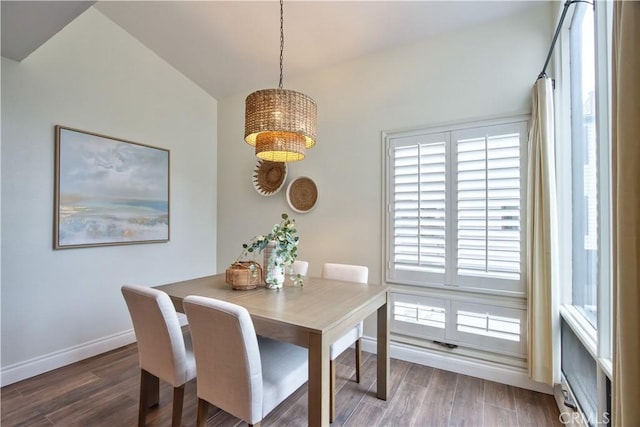 dining space featuring a chandelier, baseboards, wood finished floors, and vaulted ceiling