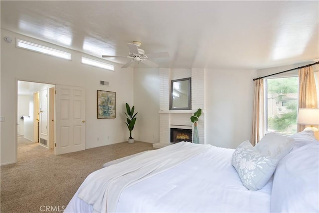 carpeted bedroom featuring visible vents, ceiling fan, and a fireplace