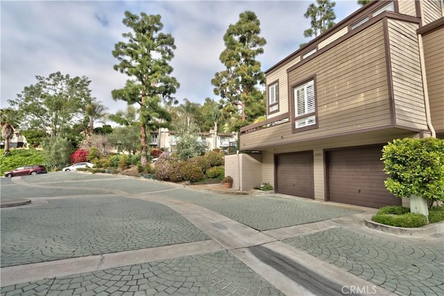 view of side of home featuring driveway and an attached garage