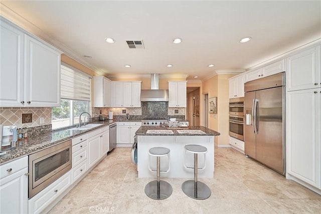 1961 W Snead St, La Habra, CA 90631 - kitchen with built in appliances, wall chimney exhaust hood, a sink, a kitchen island, and ornamental molding