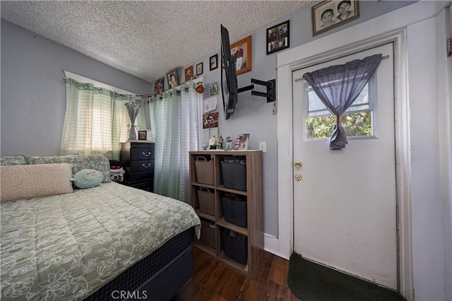 bedroom featuring a textured ceiling and dark wood-style flooring