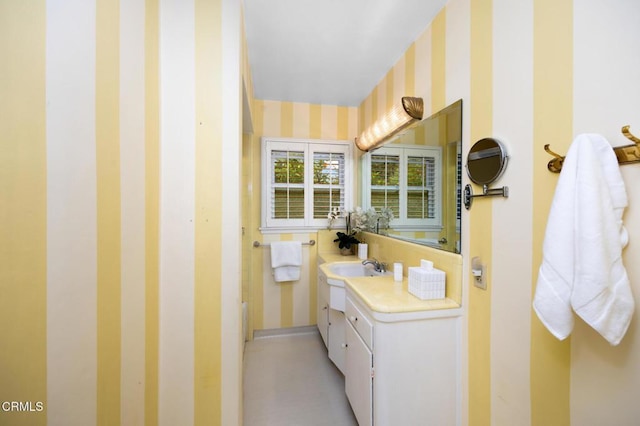 bathroom with wallpapered walls and vanity