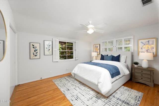 bedroom with lofted ceiling, visible vents, a ceiling fan, light wood-type flooring, and baseboards