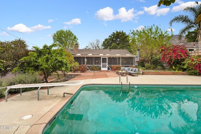 outdoor pool featuring a sunroom and a patio