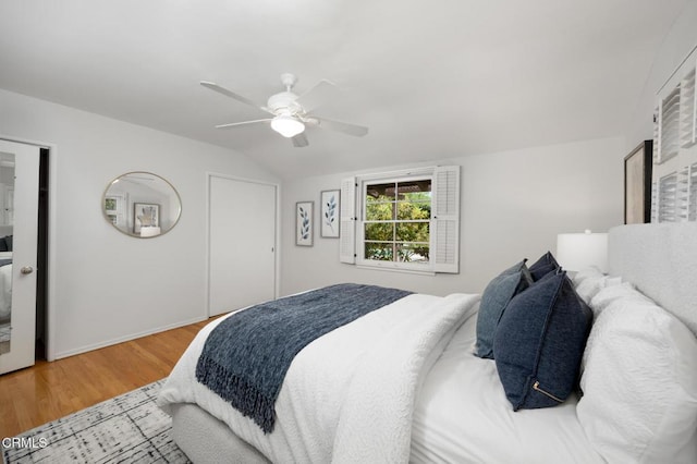 bedroom with vaulted ceiling, wood finished floors, baseboards, and ceiling fan