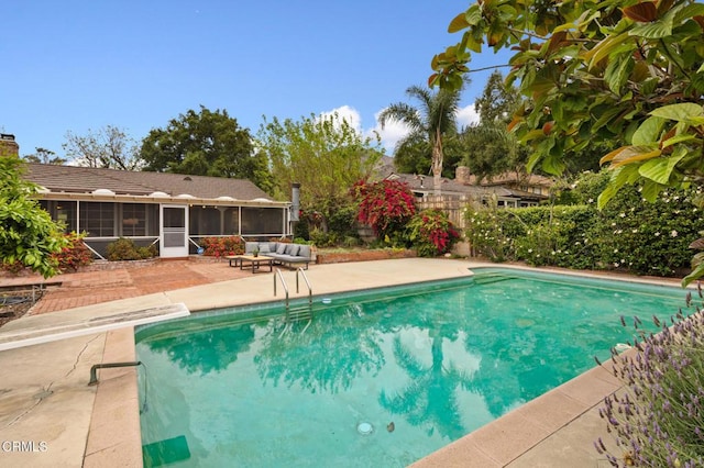 pool with fence, a sunroom, and a patio