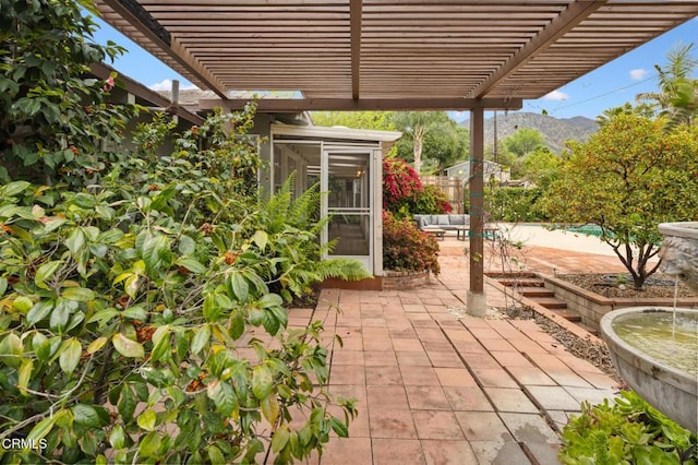 view of patio / terrace with a pergola, a sunroom, and a mountain view