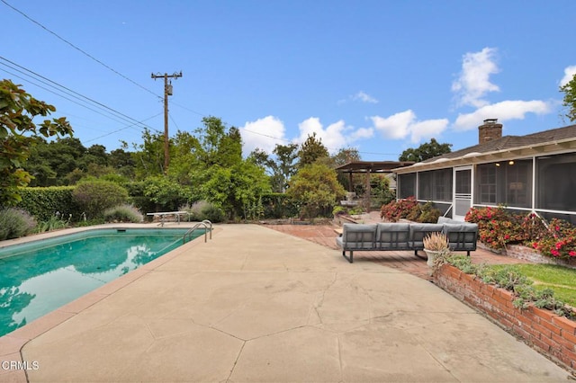 outdoor pool featuring a patio area, outdoor lounge area, and a sunroom