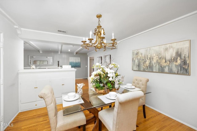 dining room featuring light wood-style floors, baseboards, a notable chandelier, beam ceiling, and visible vents