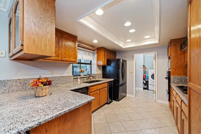 4423 N Sunflower Ave, Covina, CA 91724 - kitchen with brown cabinets, a raised ceiling, a sink, and washer / clothes dryer