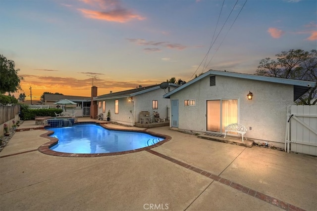 4423 N Sunflower Ave, Covina, CA 91724 - pool at dusk with a fenced backyard, a pool with connected hot tub, and a patio