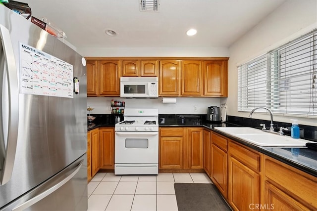4423 N Sunflower Ave, Covina, CA 91724 - kitchen with brown cabinets, visible vents, a sink, and white appliances
