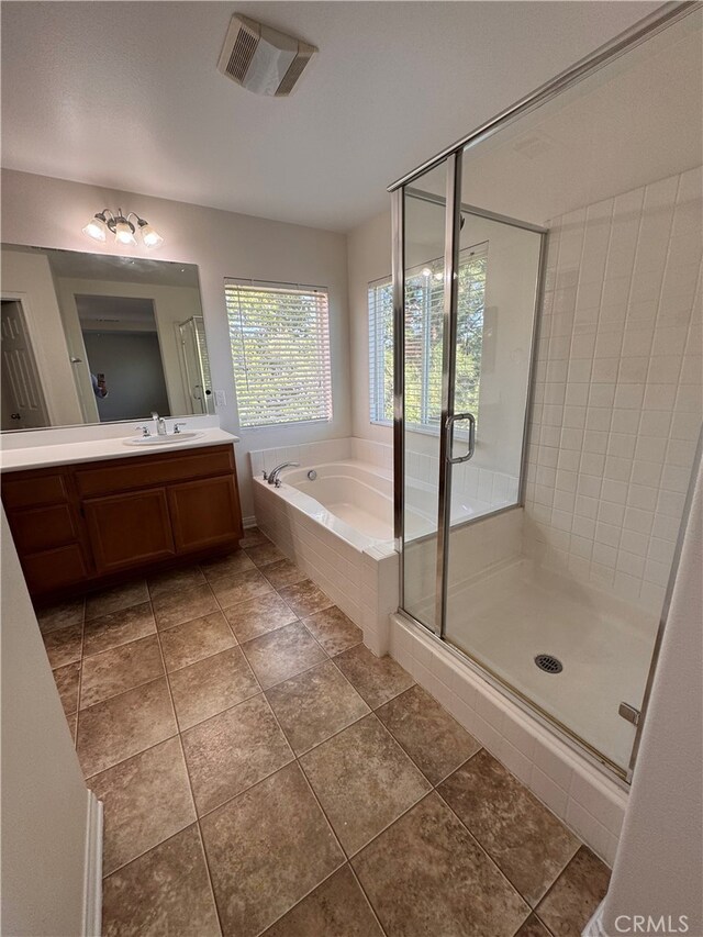 bathroom featuring vanity, a shower stall, a bath, and visible vents