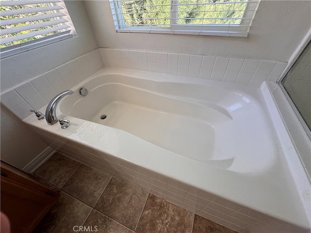 full bathroom featuring a textured wall and a bath