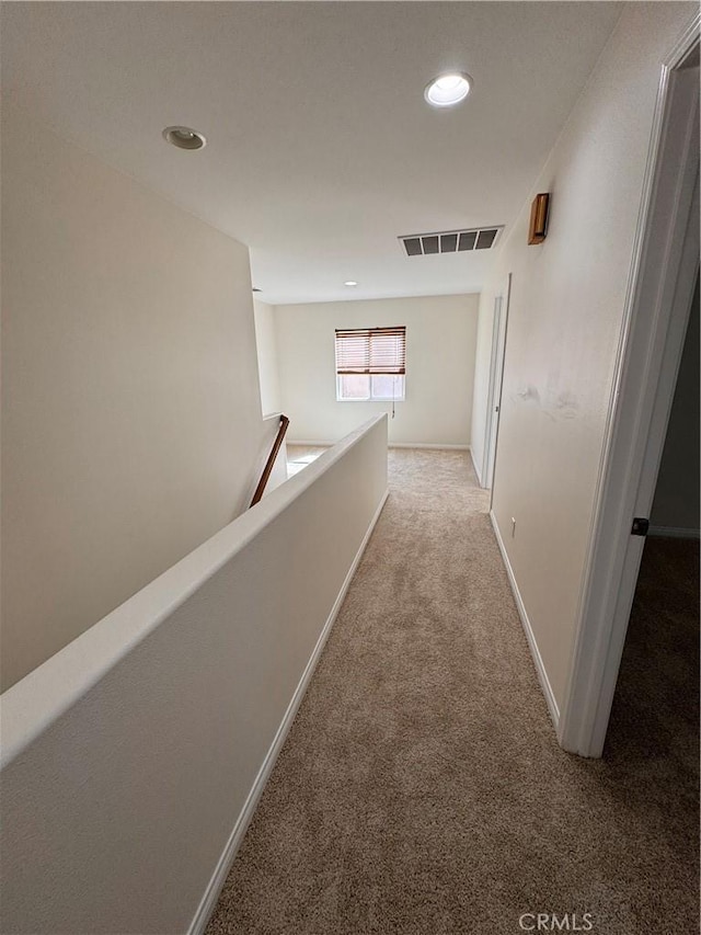 hall featuring recessed lighting, visible vents, an upstairs landing, and light carpet