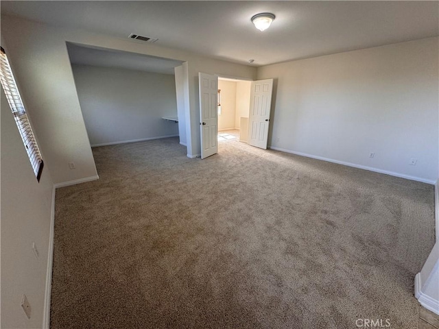 unfurnished bedroom with baseboards, visible vents, and carpet