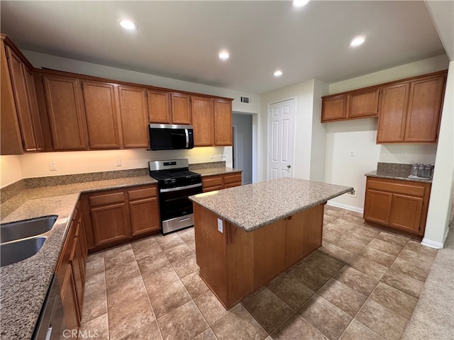 kitchen with brown cabinets, a kitchen island, recessed lighting, and appliances with stainless steel finishes
