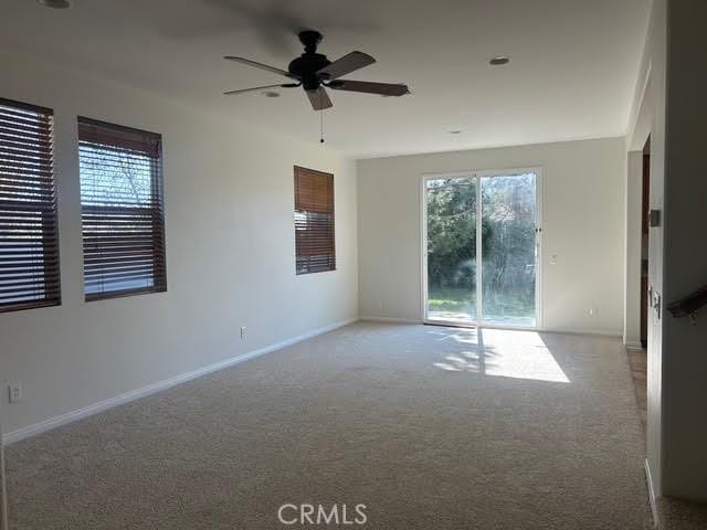 carpeted empty room with baseboards and ceiling fan