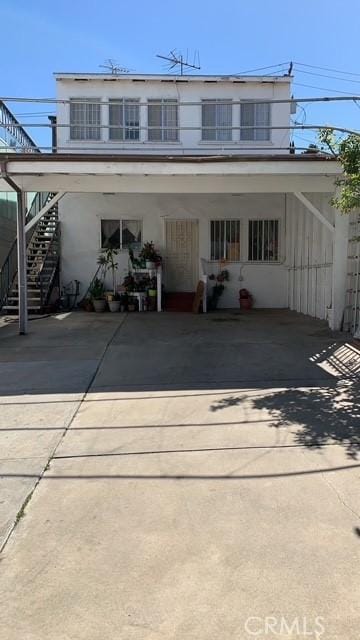 3940 City Terrace Dr, Los Angeles, CA 90063 - back of property with driveway, stairs, stucco siding, and a carport