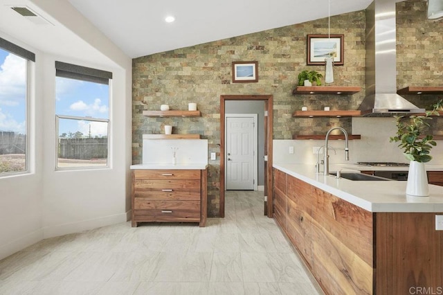 12502 Arboleda Vista Dr, Valley Center, CA 92082 - kitchen with open shelves, vaulted ceiling, brown cabinetry, wall chimney range hood, and light countertops