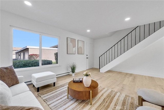 living area with stairway, baseboard heating, and wood finished floors