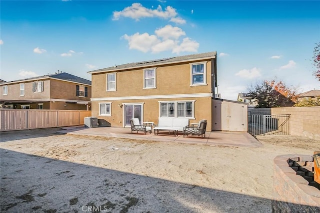 rear view of property featuring roof mounted solar panels, a patio, a fenced backyard, and stucco siding