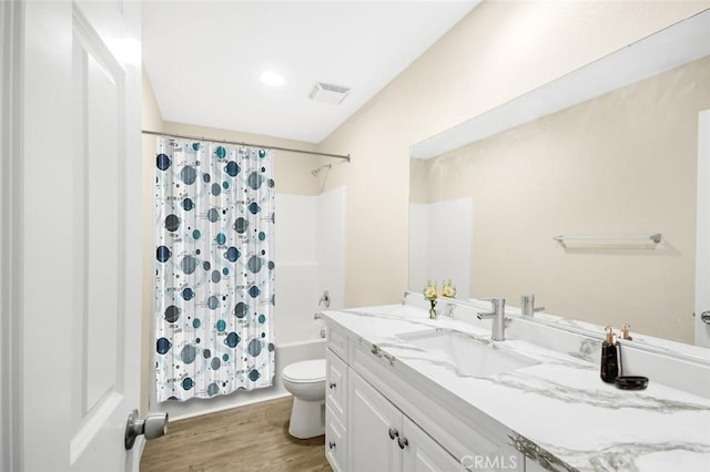 full bathroom featuring wood finished floors, vanity, shower / bathtub combination with curtain, toilet, and visible vents