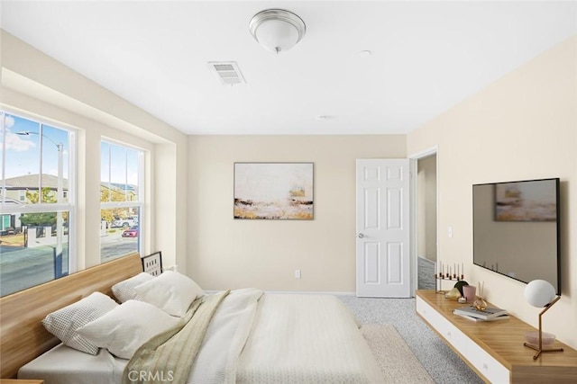 carpeted bedroom with baseboards and visible vents