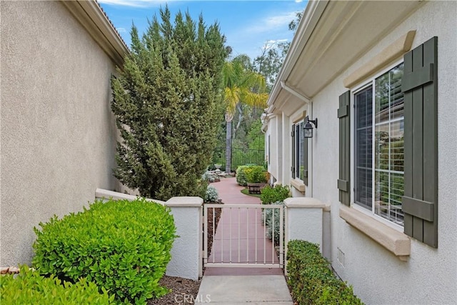40310 Via Tonada, Murrieta, CA 92562 - view of side of property featuring stucco siding, a gate, and a fenced front yard