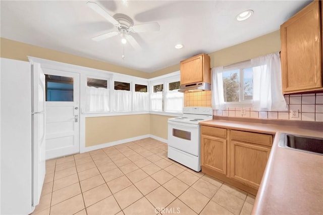 kitchen featuring under cabinet range hood, ceiling fan, white appliances, backsplash, and light countertops